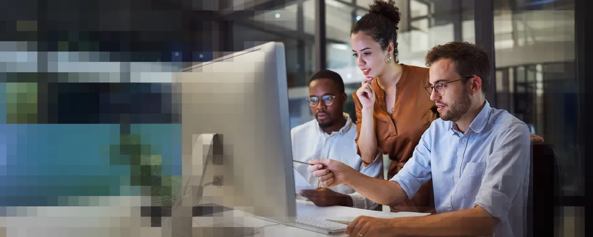 3 Personen arbeiten zusammen vor einem Monitor